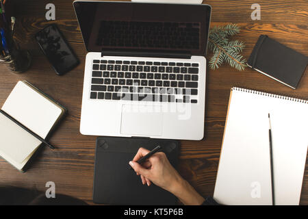 7/8 Schuß von Designer mit Grafiktablett und Arbeiten mit Laptop am Arbeitsplatz Stockfoto