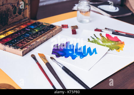 Nahaufnahme der Aquarellfarben, Pinsel und abstrakte Skizzen auf designer Arbeitsplatz Stockfoto
