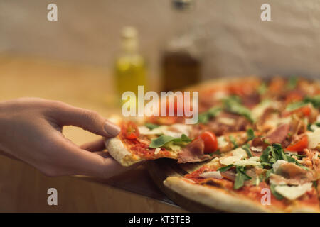 7/8 Schoß der Frau unter Stück italienische Pizza Stockfoto