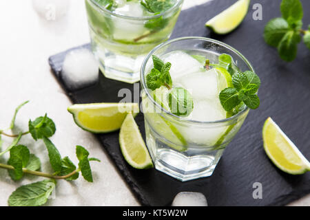 Kalte Limonade Erfrischende Sommer Mojito in einem Glas auf einer Schiefertafel Brett und Stein. Stockfoto