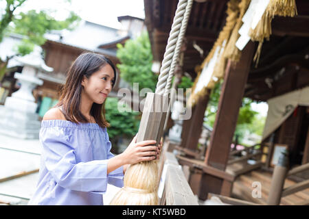 Betende Frau im japanischen Tempel mit dem Klingeln Stockfoto