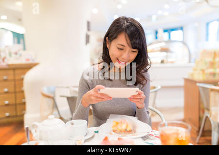 Frau unter Foto in Cake Shop Stockfoto