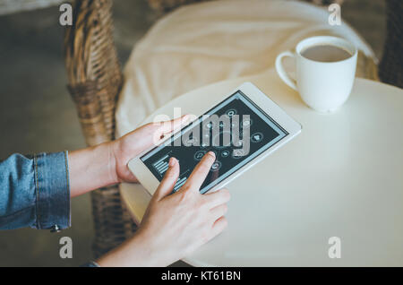 Close-up junge Frau mit Tablet mit sozialen Symbol Bildschirm im Coffee Shop. Stockfoto