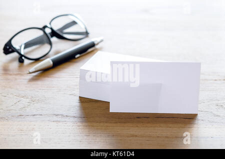 Visitenkartenvorlagen, Pen und Brillen auf Tisch. Stockfoto