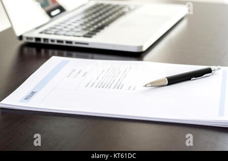 Close-up des Resume, Pen und Computer Laptop auf schwarzer Holzschreibtisch. Stockfoto