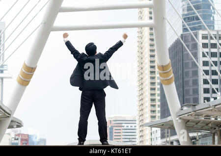 Rückseite der asiatische Geschäftsmann hands up mit glücklichen Moment. Stockfoto