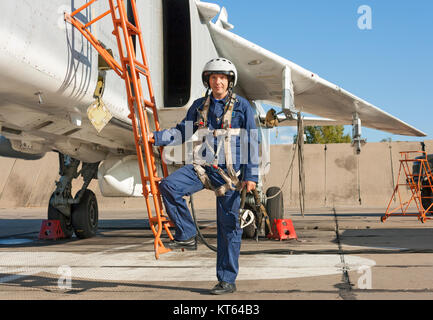 Militärpilot im Helm steht in der Nähe von Jet-Flugzeug Stockfoto