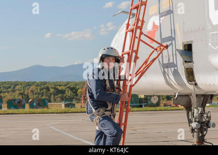 Militärpilot im Helm steht in der Nähe von Jet-Flugzeug Stockfoto