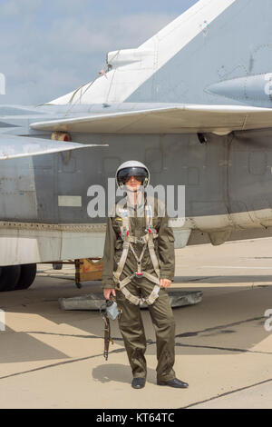 Militärpilot im Helm steht in der Nähe von Jet-Flugzeug Stockfoto