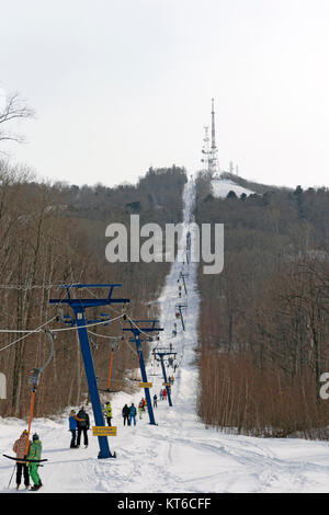 Snowboarder mit einer Fläche Aufzug auf der Piste. Stockfoto