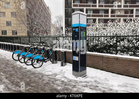 Fahrräder auf der Straße Bürgersteig geparkt mit Schnee bedeckt Stockfoto