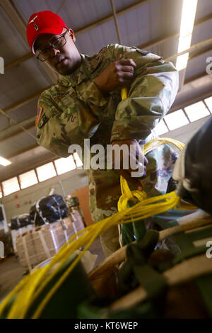 SCHOFIELD Kasernen, Hawaii - Chief Warrant Officer 3 Gregory Benson, einen fallschirmabwurf Systeme Techniker mit dem 25 Sustainment Brigade, rigs Nahrung und Wasser 7. Dezember zu niedrigen Kosten niedriger Höhe (LCLA) Air Delivery Übung der folgenden Woche. Die LCLA Lieferung Methode wird am Boden Truppen bei weniger Kosten und höhere Genauigkeit als eine der großen Höhe airdrop ist die bevorzugte Methode für leichte Verbrauchsmaterialien zu versorgen. (U.S. Armee Stockfoto