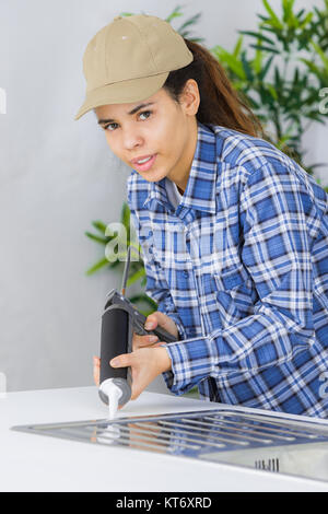 Klempner ein Silikondichtmittel zu Installieren einer Spüle