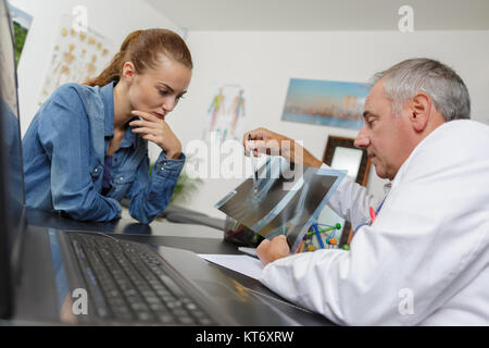 Arzt zeigt x-ray film zu Patient Stockfoto