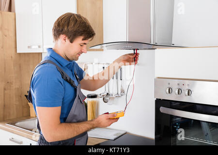 Handwerker Abzugshaube Filter prüfen. Stockfoto