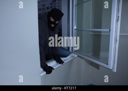 Einbrecher bricht in ein Haus Stockfoto