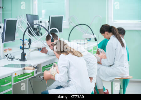 Zahnersatz, Mundhygiene. Prothetik Hände während der Arbeit am Gebiß, falsche Zähne, eine Studie und eine Tabelle mit den zahnmedizinischen Werkzeugen. Stockfoto