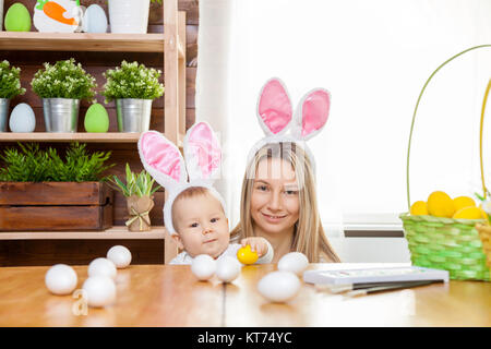 Glückliche Mutter und Ihr süßes Kind tragen Häschenohren, immer bereit für Ostern Stockfoto