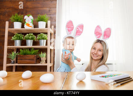 Glückliche Mutter und Ihr süßes Kind tragen Häschenohren, immer bereit für Ostern Stockfoto