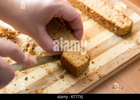 Weibliche Hände schneiden und vorbereiten Kuchen Kruste Stockfoto