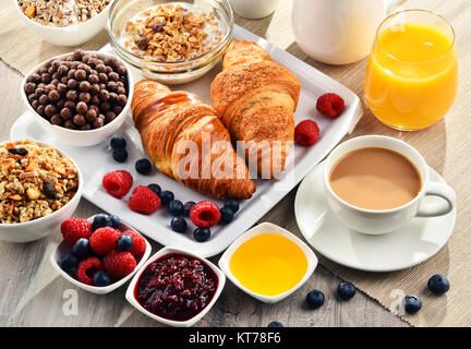 Frühstück serviert mit Kaffee, Saft, Croissants und Obst Stockfoto