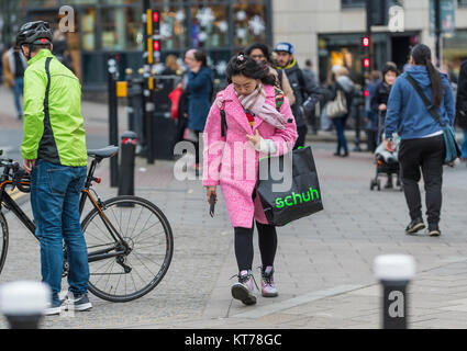 Junge asiatische Frau in teuer aussehenden Kleidung im Winter gekleidet, in der lebhaften Stadt Brighton, East Sussex, England, UK. Stockfoto
