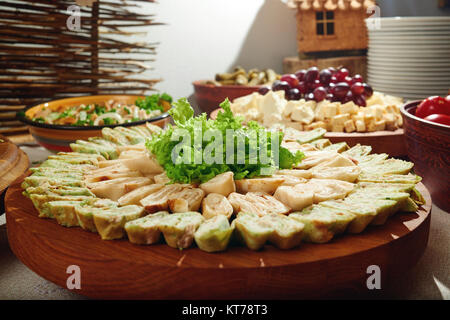 Close-up von Tapas Brötchen mit Gemüse, mit frischen grünen salatblätter eingerichtet. Es diente auf dem großen braunen Keramikplatte. Es gibt andere appet Stockfoto