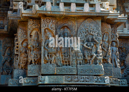 Skulpturen auf der Westseite der Mauer. Hoysaleswara Tempel, Halebidu, Karnataka, Indien. 12. jahrhundert Hindu Tempel zu Shiva gewidmet. Größte Denkmal in Halebidu Stockfoto