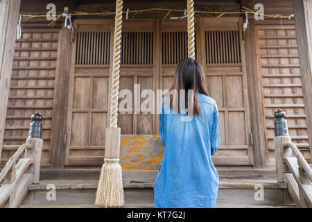 Zurück Blick auf Frau Läuten der Glocke in japanischen Tempel Stockfoto