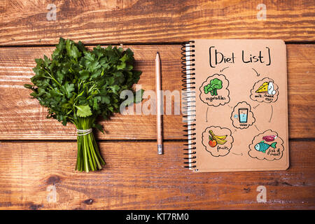 Leeres Notizbuch und Bleistift mit einem Bündel von Kräutern auf Holztisch Stockfoto