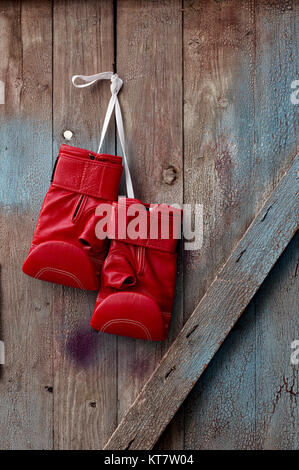 Paar rote Leder Boxhandschuhe hängen an einem Nagel Stockfoto