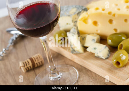 Glas Rotwein und Käse und Oliven Stockfoto