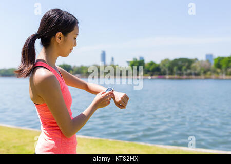 Frau Einsatz von Smart Uhr für Training Stockfoto