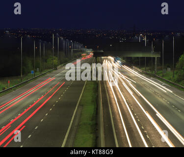 Lange Belichtung geschossen bei Sonnenuntergang leichte Wanderwege aus dem Scheinwerfer und Rücklichter von Autos entlang der M62 in der Nähe von Brighouse fahren in West Yorkshire Stockfoto