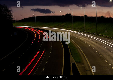 Lange Belichtung geschossen bei Sonnenuntergang leichte Wanderwege aus dem Scheinwerfer und Rücklichter von Autos entlang der M62 in der Nähe von Brighouse fahren in West Yorkshire Stockfoto