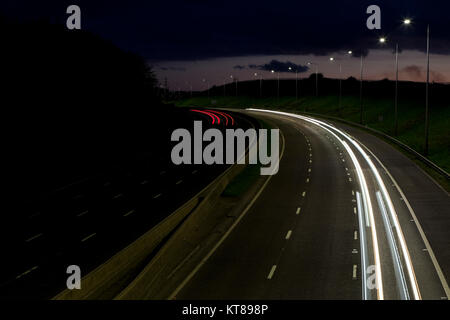 Lange Belichtung geschossen bei Sonnenuntergang leichte Wanderwege aus dem Scheinwerfer und Rücklichter von Autos entlang der M62 in der Nähe von Brighouse fahren in West Yorkshire Stockfoto