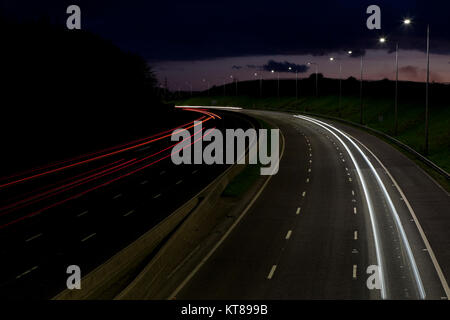 Lange Belichtung geschossen bei Sonnenuntergang leichte Wanderwege aus dem Scheinwerfer und Rücklichter von Autos entlang der M62 in der Nähe von Brighouse fahren in West Yorkshire Stockfoto