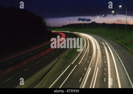 Lange Belichtung geschossen bei Sonnenuntergang leichte Wanderwege aus dem Scheinwerfer und Rücklichter von Autos entlang der M62 in der Nähe von Brighouse fahren in West Yorkshire Stockfoto