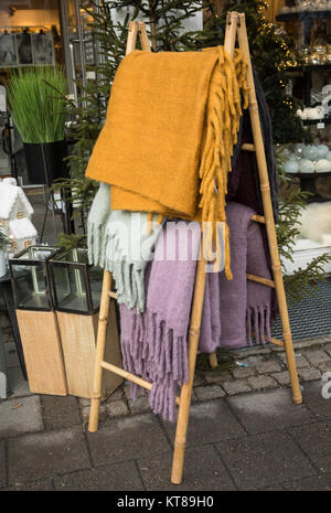 Farbenfrohe warme Wolldecken und Plaids hängend auf einer hölzernen Rack außerhalb ein Geschenk Shop Stockfoto