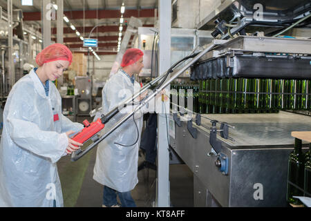 Positive Weingut Arbeiter mit der Abfüllung von Maschinen im Werk Stockfoto