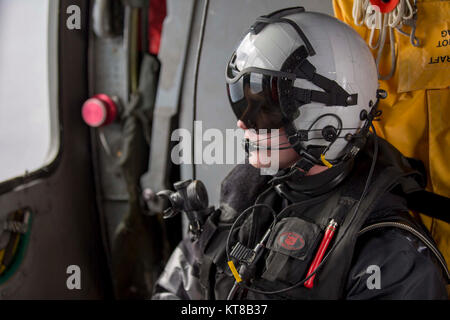 Naval Air Crewman (Hubschrauber) 3. Klasse Mike Kane von der "Dragon Wale" von Hubschrauber Meer Combat Squadron (HSC), 28. Führt die Aufgaben einer Suche und Rettung Schwimmer in einem MH-60S Sea Hawk bei Flugbetrieb an Bord der Nimitz-Klasse Flugzeugträger USS Abraham Lincoln (CVN 72). (U.S. Marine Stockfoto