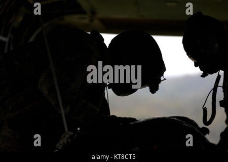 SCHOFIELD Kasernen, Hawaii-SPC. Logan Mattix (Links), eine CH-47 Chinook Crew Chief mit dem 25 Combat Aviation Brigade, und Chief Warrant Officer 3 Gregory Benson (Rechts), einen fallschirmabwurf Systeme Techniker mit dem 25 Sustainment Brigade, bereiten einen manipulierten low cost Low Altitude (LCLA) Last bei Kahuku Training Area 12 Dezember fallen zu lassen, während eine Lieferung. Die LCLA Lieferung Methode wird am Boden Truppen bei weniger Kosten und höhere Genauigkeit als eine der großen Höhe airdrop ist die bevorzugte Methode für leichte Verbrauchsmaterialien zu versorgen. (U.S. Armee Stockfoto