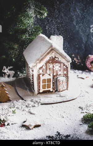 Hausgemachte Lebkuchen Haus in den Bergen, Tannenbaum und künstlichen Schnee. Vertikale Komposition, selektiven Fokus Stockfoto