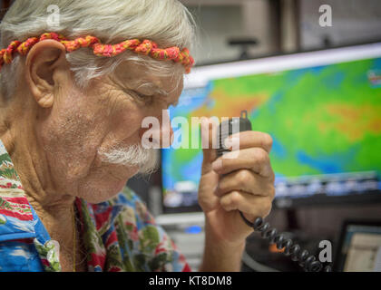 Bruce Best, Universität von Guam Forscher, kommuniziert mit den Piloten während des Betriebs Weihnachten Fallen, an der Universität von Guam, Guam, Dez. 13, 2017. Jedes Jahr im Dezember, C-130J Super Hercules Besatzungen von Yokota Air Base Kopf zu Andersen Air Force Base low-cost, low-altitude Fallschirmabwürfen zu Inselbewohner im gesamten Commonwealth der Nördlichen Marianen, die Föderierten Staaten von Mikronesien und der Republik Palau. (U.S. Air Force Stockfoto