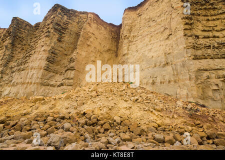 Eine riesige Klippe fallen aus Sandstein vom East Cliff Leckagen an den Strand nach einem Wintersturm an der Jurassic Coast, in der Nähe von West Bay, Dorset, England, Großbritannien Stockfoto