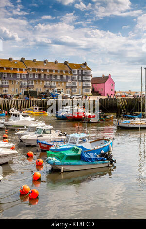 Eine bunte Sammlung von Fischereifahrzeugen und Sportbooten im Hafen an der West Bay an der Jurassic Coast in Dorset, England, Großbritannien Stockfoto