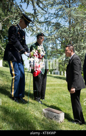 Die Teilnehmer der Zeremonie zu Ehren der Hmong und Lao Bekämpfung der Veteranen am Denkmal Baum und Plakette in Arlington National Cemetery, 15. Mai 2015, legen einen Kranz an der Gedenktafel. Die Plakette liest, im Teil, "in Erinnerung an den Hmong und Lao bekämpfen Veteranen und ihre amerikanischen Berater, die die Freiheit in Südostasien verursacht. Ihre patriotische Tapferkeit und Treue in der Verteidigung der Freiheit und der Demokratie wird nie vergessen werden." (aus den USA Armee Foto von Rachel Larue/freigegeben) Stockfoto