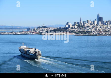Containerschiff Maui Segel in der Bucht von San Francisco unter der Golden Gate Bridge mit SF Skyline im Hintergrund Stockfoto