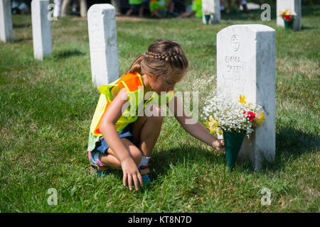 Makenna Bell legt Blumen an ein Grab in Abschnitt 21 von Arlington National Cemetery, Arlington, Virginia, 17. Juli 2017. Über 400 freiwillige Landschaft Fachleute in der Nationalen Vereinigung der Landschaft Professionals' 21. jährliche Erneuerung teilgenommen und die Erinnerung an ANC. (U.S. Armee Foto von Elizabeth Fraser/Arlington National Cemetery/freigegeben) Stockfoto