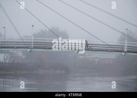 Aberystwyth Wales UK, Freitag, 22. Dezember 2017 Großbritannien Wetter: Dichter Nebel und Dunst des Triebwerks die Fußgängerbrücke über das ruhige Wasser des Flusses Reheidol in Aberystwyth, Ceredigion, West Wales, auf eine sehr milde (11°C) und einen ruhigen Vormittag in der Leitung bis zu Weihnachten 2017 Photo Credit: Keith Morris/Alamy leben Nachrichten Stockfoto